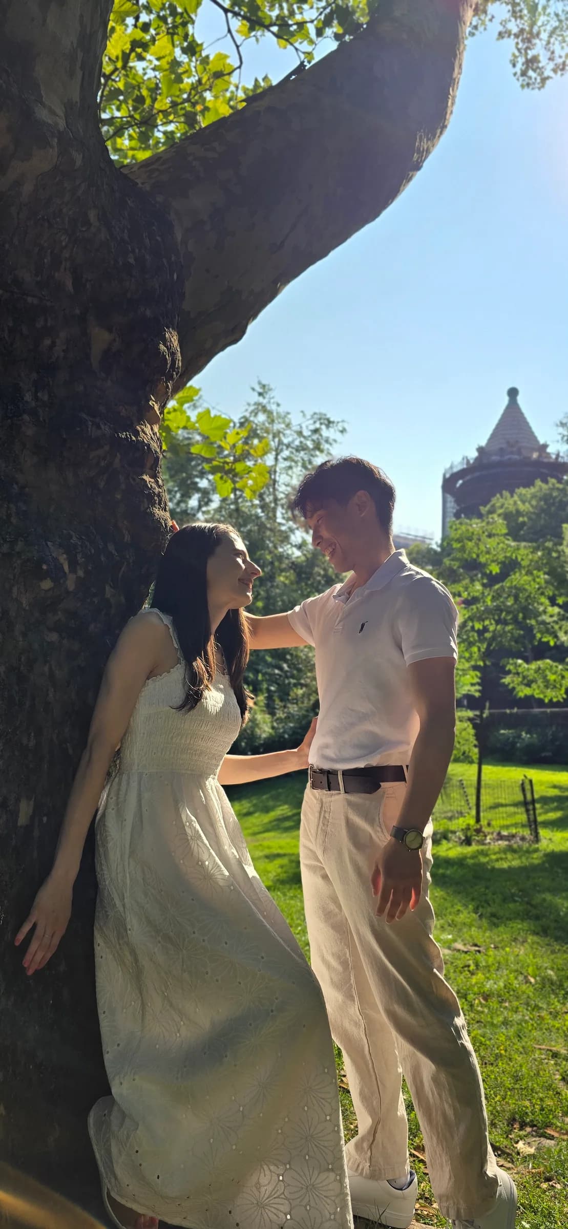 The couple smiling together in a vertical outdoor portrait
